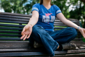 Female entrepreneur Marketing Coach meditating on a park bench